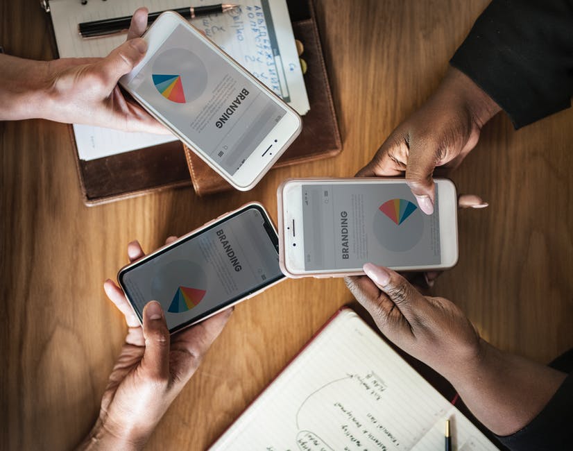 people with mobile phones working on branding and logo